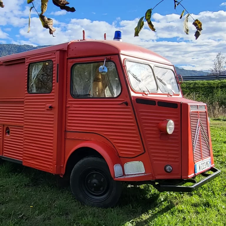 Photo du côté du van "Pimpon" qui est un van rouge ancien camion de pomier de la marque Citroën
